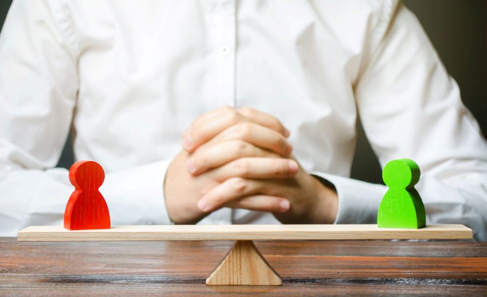 Image of a man with hands clasped, looking at scales with green and red balance, featuring 411 Corporate Law and highlighting 'Conciliation,' ensuring it aligns with the page's context on dispute resolution and legal conciliation.