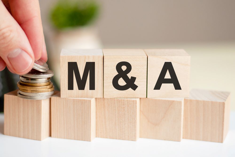Image of the concept word 'M AND A' displayed on wooden blocks against a green background, featuring 411 Corporate Law and highlighting Mergers & Acquisitions (M&A), ensuring it aligns with the page's context on corporate transactions.