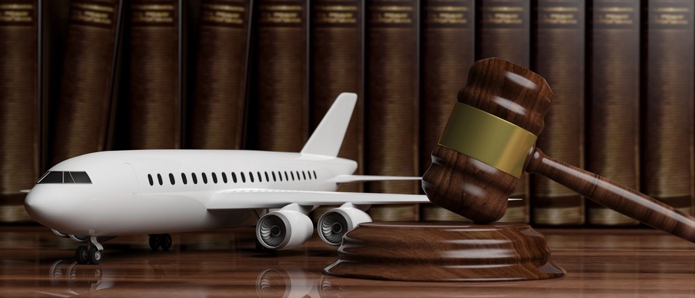 Image of a blank commercial airplane next to a judge's gavel resting on legal books, featuring 411 Corporate Law and highlighting the complexities of international corporate law, ensuring it aligns with the page's context on aviation law and corporate regulations.
